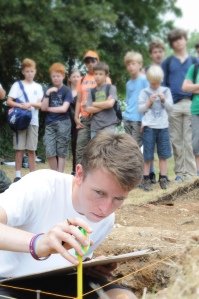 Archaeologist measures a section during a presentation to local school children